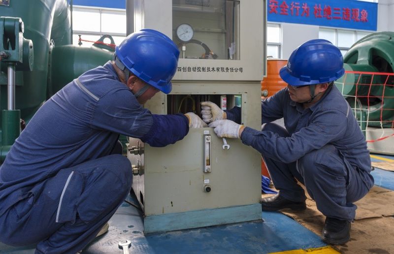 2.靖西供電公司工作人員在峒牌發(fā)電站對(duì)調(diào)整器進(jìn)行檢修維護(hù)。駱衍利攝.JPG